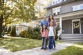 Portrait Of Smiling Family Standing In Front Of Their Home