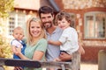 Portrait Of Smiling Family Standing By Gate Outside Home In Countryside Together Royalty Free Stock Photo