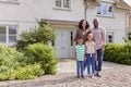 Portrait Of Smiling Family Standing Outside Home Together Royalty Free Stock Photo