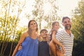 Portrait Of Smiling Family In Summer Garden With Father Giving Daughter Piggyback Ride On Back Royalty Free Stock Photo