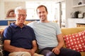 Portrait Of Smiling Father With Adult Son Relaxing On Sofa At Home Royalty Free Stock Photo