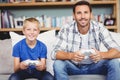 Portrait of smiling father and son playing video game Royalty Free Stock Photo