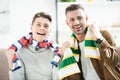 Portrait of smiling father and teen son in scarfs watching sport match Royalty Free Stock Photo