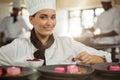 Portrait of smiling female chef finishing dessert plates Royalty Free Stock Photo