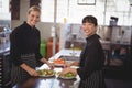 Smiling female chefs with fresh food in plates on kitchen counter Royalty Free Stock Photo