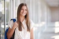 Portrait Of Smiling Female College Student With Backpack In Corridor Of Building