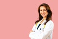 Portrait of smiling female doctor with arms crossed on pink studio background Royalty Free Stock Photo