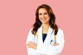 Portrait of smiling female doctor with arms crossed on pink studio background Royalty Free Stock Photo