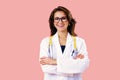 Portrait of smiling female doctor in glasses with arms crossed on pink studio background Royalty Free Stock Photo