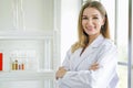 Smiling female doctor in lab coat with arms crossed against. Royalty Free Stock Photo