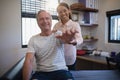 Portrait of smiling female doctor and senior male patient with arms raised Royalty Free Stock Photo