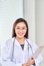 Portrait of smiling female doctor standing posing in her hospital office Royalty Free Stock Photo