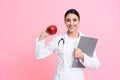 Portrait of smiling female doctor with stethoscope holding red apple isolated. Royalty Free Stock Photo