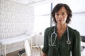 Portrait Of Smiling Female Doctor With Stethoscope Standing By Desk In Office Royalty Free Stock Photo