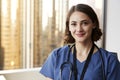 Portrait Of Smiling Female Doctor Wearing Scrubs With Stethoscope In Hospital Office Royalty Free Stock Photo