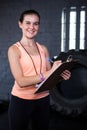 Portrait of smiling female fitness instructor writing in clipboard Royalty Free Stock Photo