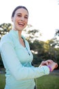 Portrait of smiling female jogger checking her fitness band