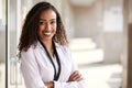 Portrait Of Smiling Female School Teacher Standing In Corridor Of College Building