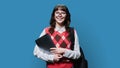 Portrait of smiling female student with laptop backpack, on blue background Royalty Free Stock Photo