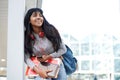 Smiling female student with mobile phone, books and bag Royalty Free Stock Photo