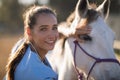 Portrait of smiling female vet checking horse