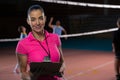 Portrait of female volleyball coach holding clipboard
