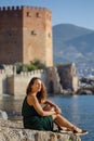 Travelling to Alanya. Smiling female sitting by the sea in front