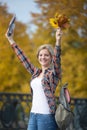 Portrait of smiling female young student outdoors holding yellow leaves Royalty Free Stock Photo