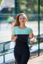 Portrait of smiling fit woman running at sports ground Royalty Free Stock Photo