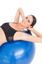 Portrait of a smiling fit woman stretching on fitness ball Royalty Free Stock Photo