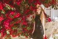 Portrait of smiling girl in black dress among purple bougainvillaea Royalty Free Stock Photo