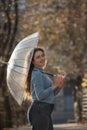 Portrait of smiling girl with blue eyes and curly hair under transparent umbrella. Young woman in blue sweater Royalty Free Stock Photo