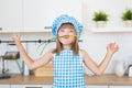 Portrait of smiling girl in cook clothes funs with bunch onion on a kitchen Royalty Free Stock Photo