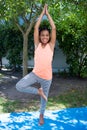 Portrait of smiling girl doing tree pose yoga Royalty Free Stock Photo