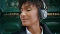 Portrait smiling girl headphones standing near vintage door. Woman in earphones Royalty Free Stock Photo