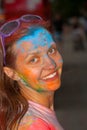 Portrait smiling girl in multi-colored paint during the celebration of Solor Fest. Smiling pretty girl.