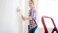 Portrait of smiling young girl painting walls with white paint Royalty Free Stock Photo