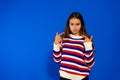 Portrait of smiling girl pointing at herself, bragging, rejoicing at winning, proud of achievement, wearing striped