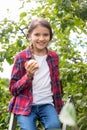 Portrait of smiling girl sitting on stepladder and biting fresh