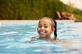 Portrait Of Smiling Girl On Summer Holiday Having Fun Splashing In Outdoor Swimming Pool Royalty Free Stock Photo