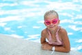 Portrait smiling girl in swimming pool, child in swimming glasses and inflatable sleeves. Summer travel hotel vacation Royalty Free Stock Photo