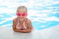 Portrait smiling girl in swimming pool, child in swimming glasses and inflatable sleeves. Summer travel hotel vacation Royalty Free Stock Photo
