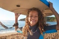 Portrait Of Smiling Girl Wearing Wetsuit Carrying Bodyboards On  Summer Beach Vacation Royalty Free Stock Photo