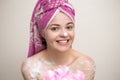 Portrait of smiling girl woman with wet hair wrapped in pink towel taking shower or bath with foam and lather of soap. Royalty Free Stock Photo