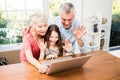 Portrait of smiling grandparents and granddaughter using laptop Royalty Free Stock Photo