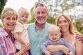 Portrait Of Smiling Grandparents With Mother And Grandchildren At Home In Garden Together