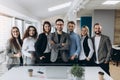 Portrait of a smiling group of diverse corporate colleagues standing in a row together in a bright modern office Royalty Free Stock Photo