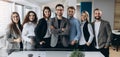 Portrait of a smiling group of diverse corporate colleagues standing in a row together in a bright modern office Royalty Free Stock Photo