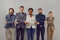 Portrait of a smiling group of diverse multiracial business people standing in a row holding hands.