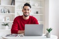 Portrait Of Smiling Handsome Arab Male Freelancer Posing At Desk With Laptop Royalty Free Stock Photo